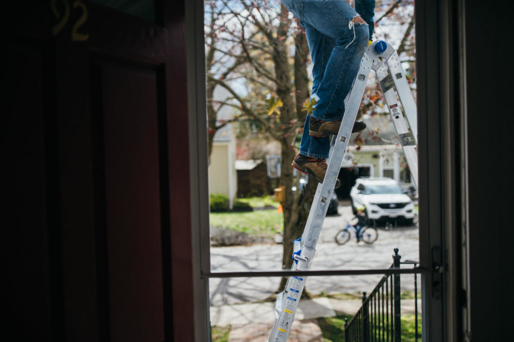 working on home projects while on a ladder belmont family photography