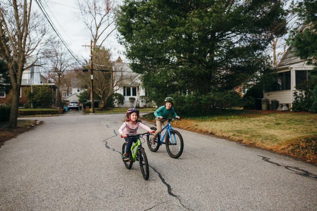 two happy kids riding bikes in the street