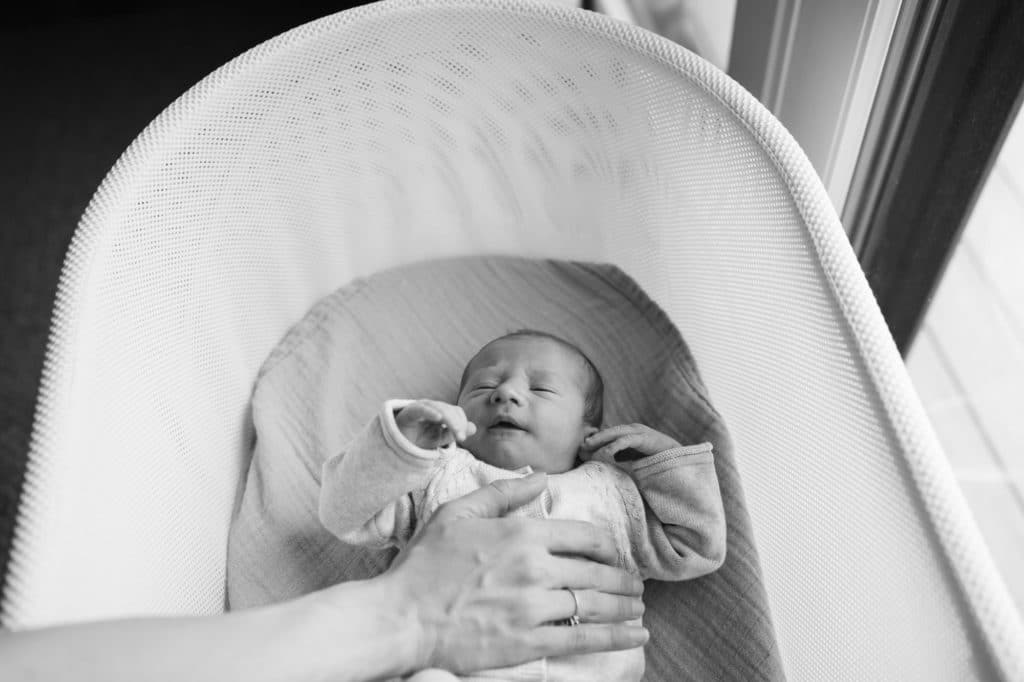 black and white photo of baby in crib