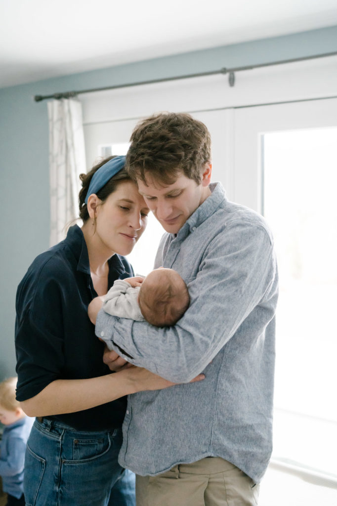 in-home Boston photography session mom and dad with newborn baby 
