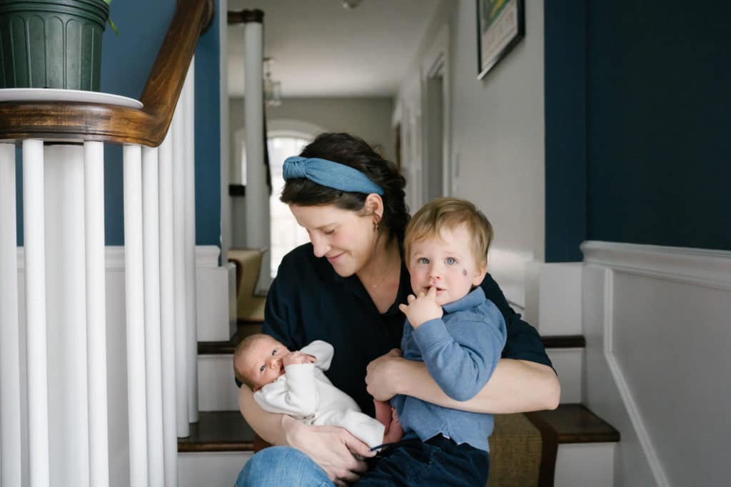 in-home Boston photography session mom holding toddler and new baby 