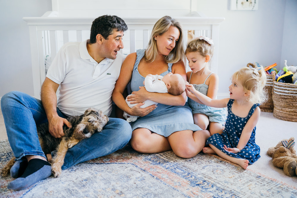 family sitting on floor in nursery newborn photographer in Boston