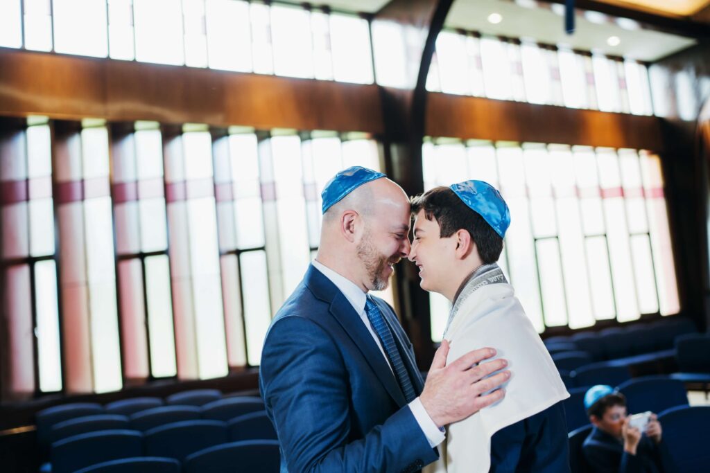 Father and son with heads together at bar mitzvah Boston